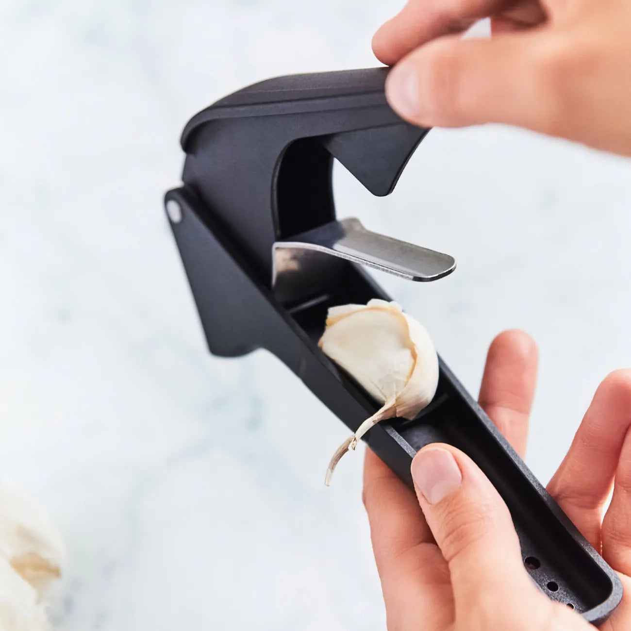 Knoblauchpresse Knobi-Star von der Marke Tupperware / Drei in Eins Küchenwerkzeug / zum Schälen und Pressen von Knoblauch / mit Kräuterentblätterungsfunktion / mit Ergonomischen Griff / Einfach zu Reinigen / Hier direkt online kaufen 