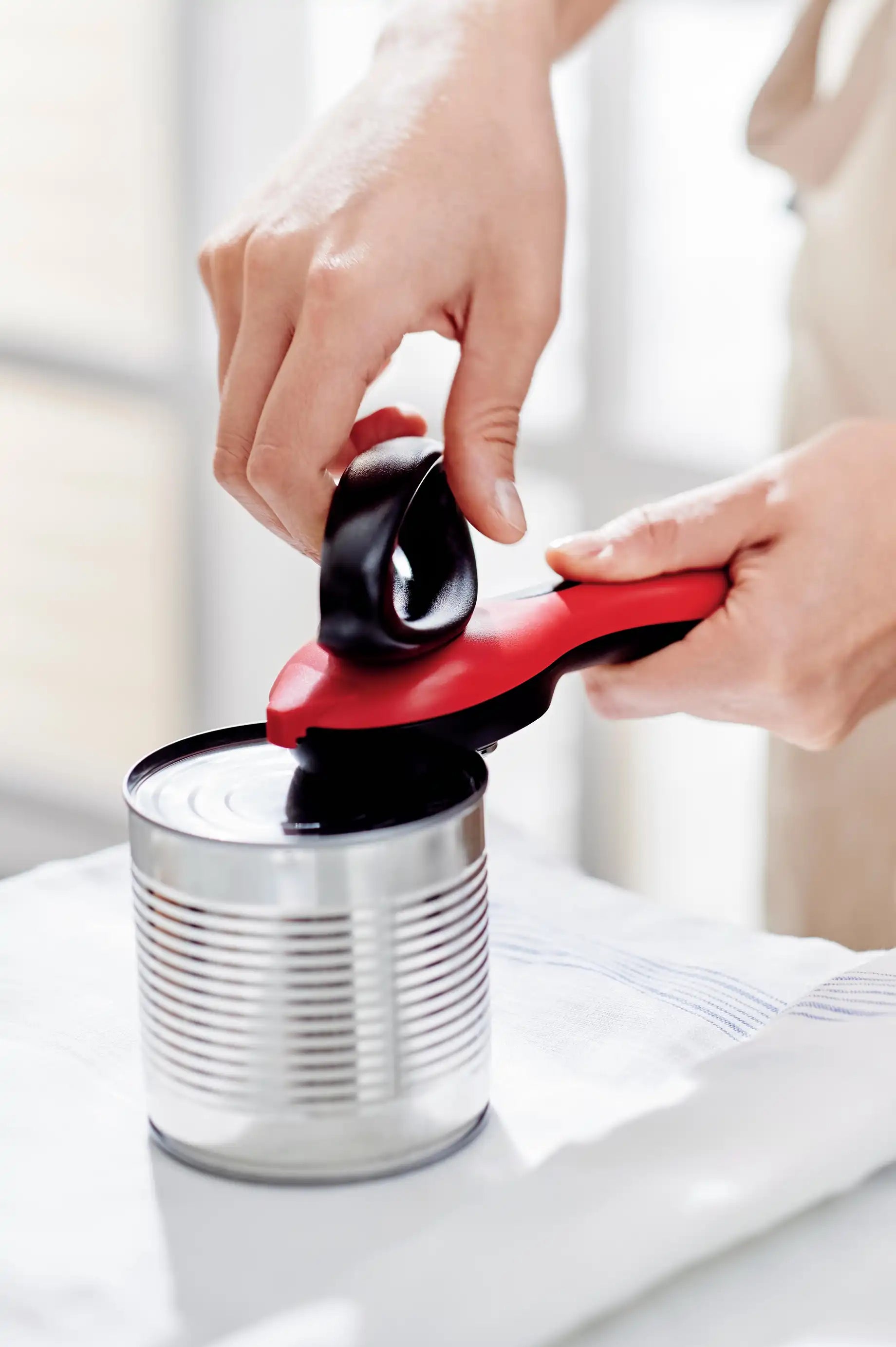 Dosenöffner von der Marke Tupperware in der Farbe Rot / mit sicherem Mechanismus gegen Scharfe Kanten / Einfach und Solide / sorgt für abgerundete Schnittkanten / Komfort dank ergonomisch geformten Griff / mit Greifer zum abnehmen des Abgeschnittenen Deckels / Hier direkt online kaufen 