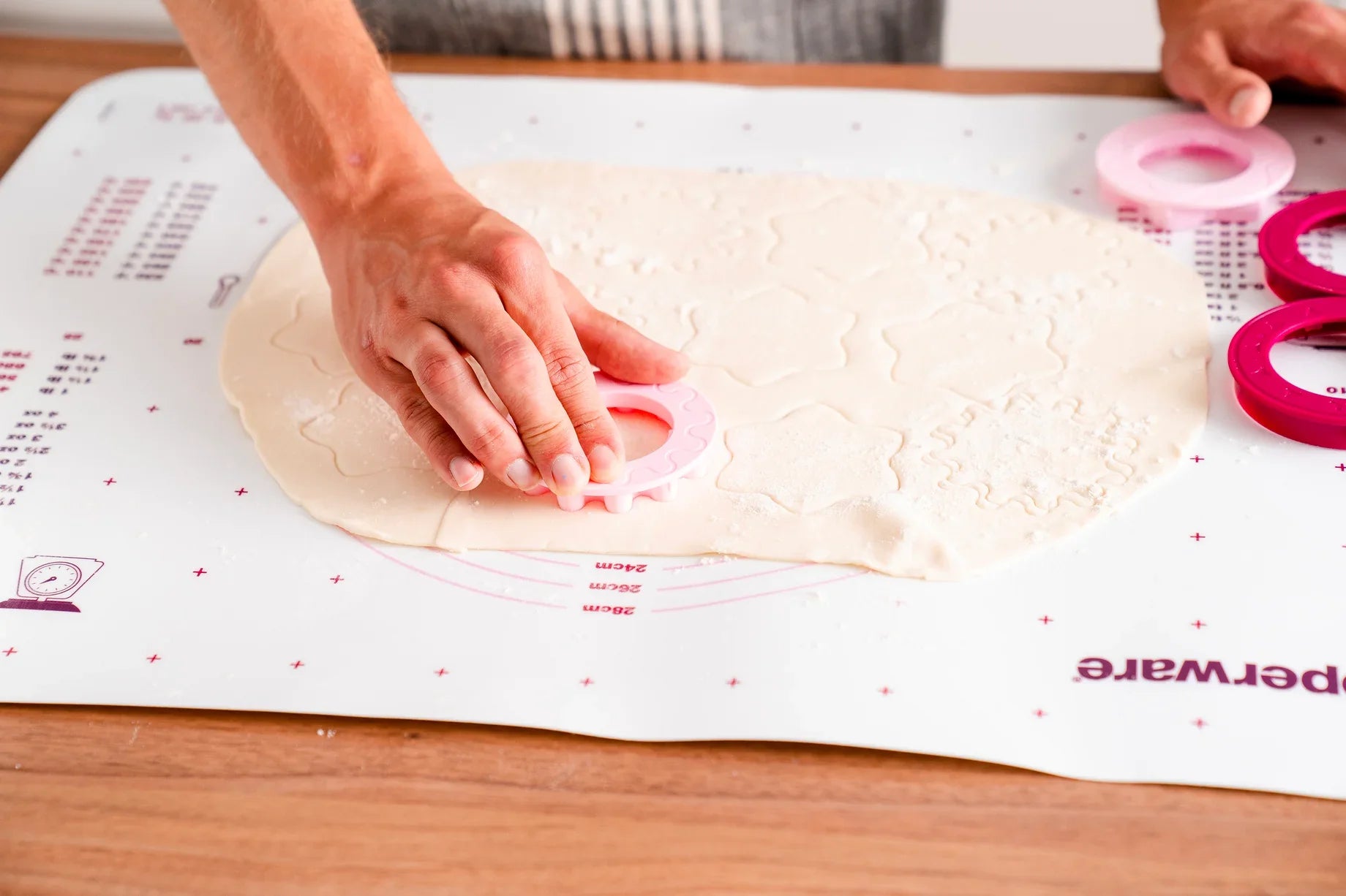 Teigunterlage von der Marke Tupperware / rutschfest / Praktisch und Ideal für alle Großen und kleinen Backkünstler / mit Praktisch granulierter Oberfläche / mit Markierungen von Handelsüblichen Springformen, Backblechen und Umrechnungstabellen / Beispielbild Plätzchenteig ausgerollt / Hier direkt online kaufen 