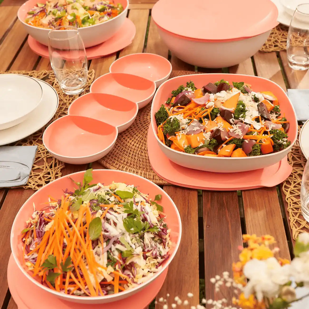 Tupperware Allegra Servier-Perle Lachs leer neben Allegra-Salatschüsseln auf gedecktem Gartentisch