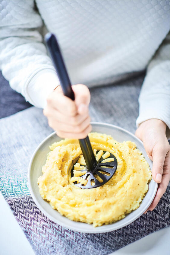Pürier Meister von der Marke Tupperware / Kartoffelstampfer in der Farbe Schwarz / einfaches und schnelles Stampfen / der Stampfer kommt auch gut in die ecken von Schüsseln und Töpfen / Beispielbild Kartoffelstampfer beim Stampfen / Hier direkt online kaufen