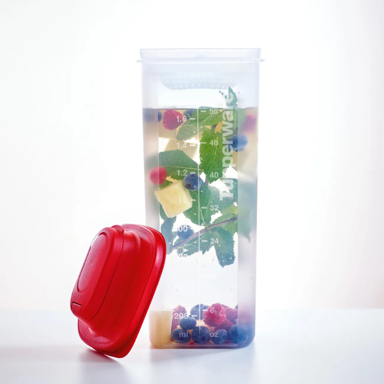 Slim Line Kanne 2l mit Sieb von der Marke Tupperware / auslaufsicher und langlebig / Ideal zum Aufbewahren und Servieren / Passt in die Kühlschranktür / Einfach zu halten / Ideal für Unterwegs / Spülmaschienenfest / Beispielbild gefüllt mit Obst Wasser / Hier direkt online kaufen 