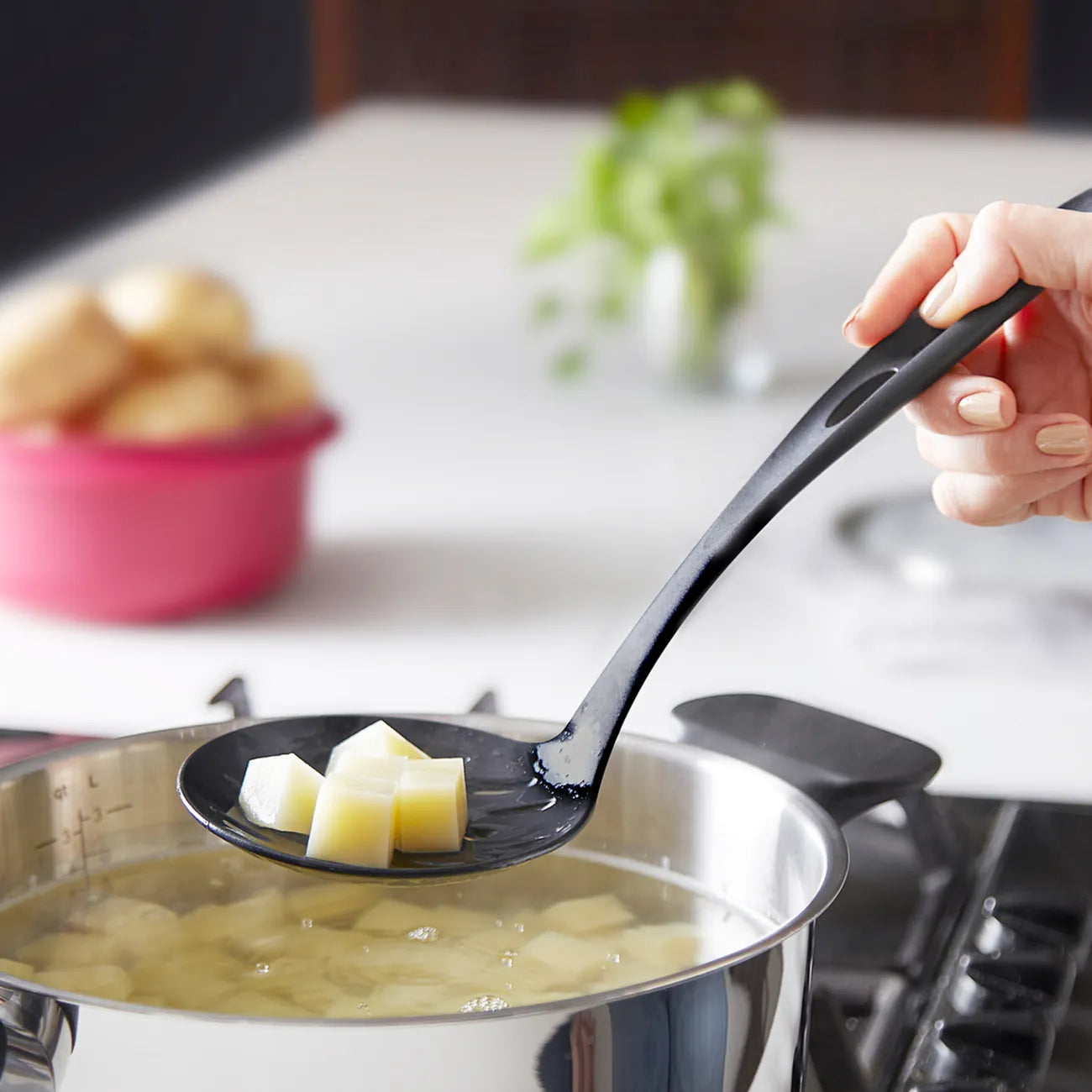 Schaumlöffel Küchenfreund von der Marke Tupperware in der Farbe Schwarz / zum Herausnehmen von Lebensmitteln aus Kochendem Wasser / Beispielbild Kartoffeln herausnehmen / Hier direkt online kaufen 