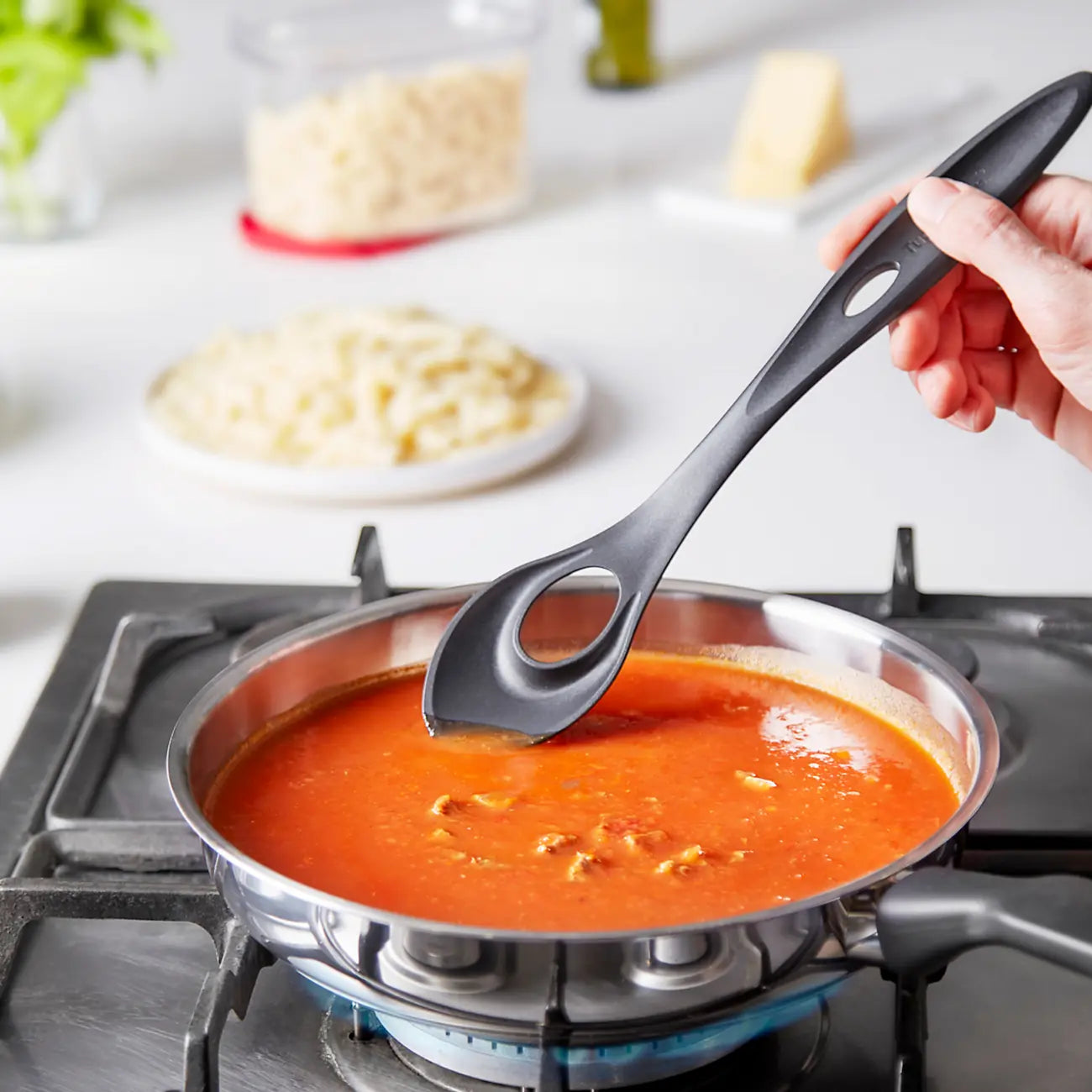 Rührlöffel Küchenfreund von der Marke Tupperware / zum Mischen, Rühren und Servieren / mit loch zum Aufhängen / Robust und Langlebig / Beispielbild Rührlöffel am Soße Rühren / Hier direkt online kaufen 