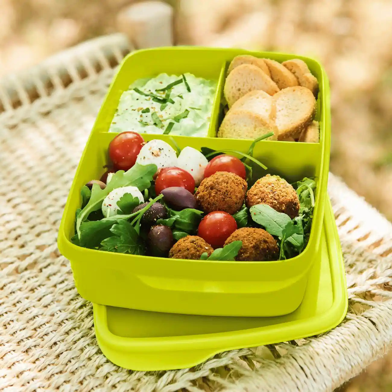 ECO+ Lunch Box Pausen 1 L von der Marke Tupperware in der Farbe Grün / fest verschließbar / mit 3 Fächern / Dank flacher Form passt sie auch in die Handtasche / abnehmbarer Deckel / leicht zu öffnen / Beispielbild gefüllt mit Snacks / Hier direkt online kaufen 
