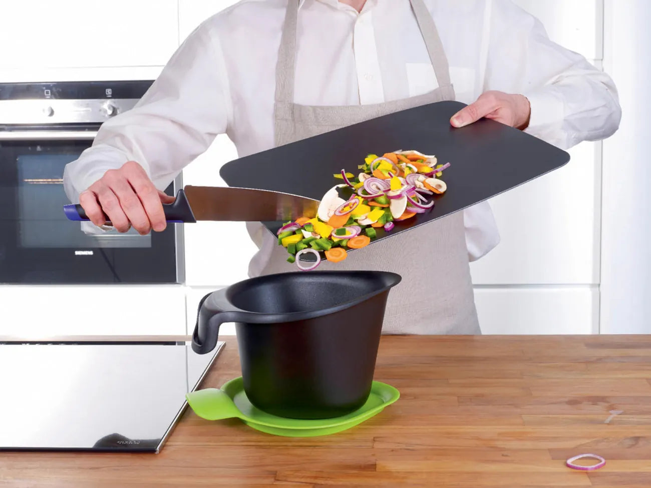 Schneidflex Schneidunterlage von der Marke Tupperware / in der Farbe Schwarz / mit rutschfester Unterseite / flexibles Material zum Idealen Schütten von Schneidgut / Hier direkt online kaufen 