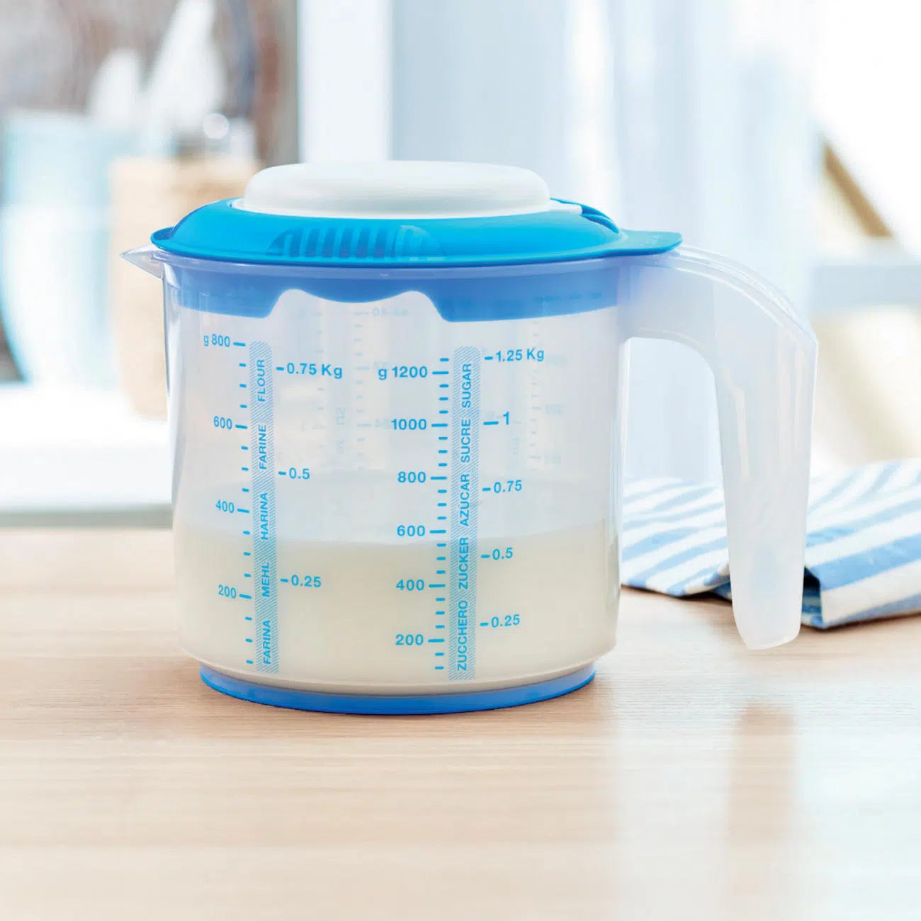 Rühr Mix 1,25 L Messbecher von der Marke Tupperware / in der Farbe Blau / zum Messen, mixen und rühren / inklusive Spritzschutzdeckel / mit Anti- Rutschring / Rührlöffelhalterung im Griff / Hier direkt online kaufen