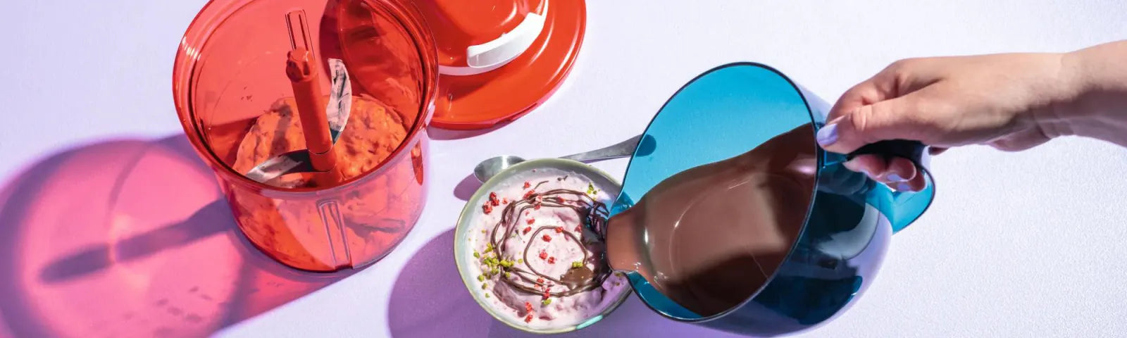 Tupperware® MicroCook-Kanne gießt flüssige Schokolade über Eis, daneben Eis am Stiel in Waffelform und rote Küchenhelfer – Tupperware® Beratung, Tupper®-Party und Bestellung in Korschenbroich (41352), Rhein-Kreis Neuss, Niederrhein